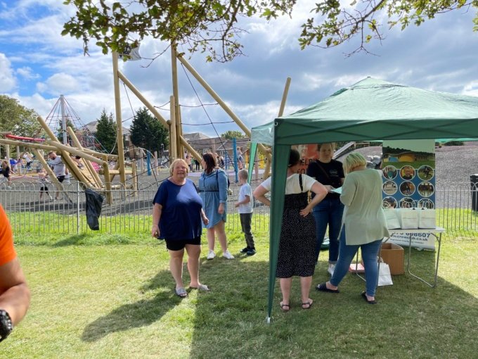 neighbours looking at stalls middle park whitehawk wooden pirate ship in background